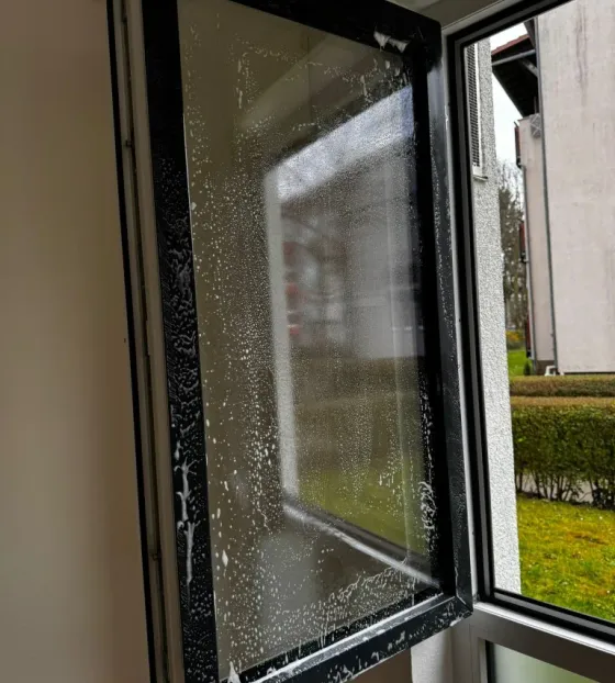 Fensterreinigung mit aufgetragenem Reinigungsmittel am geöffneten Fenster